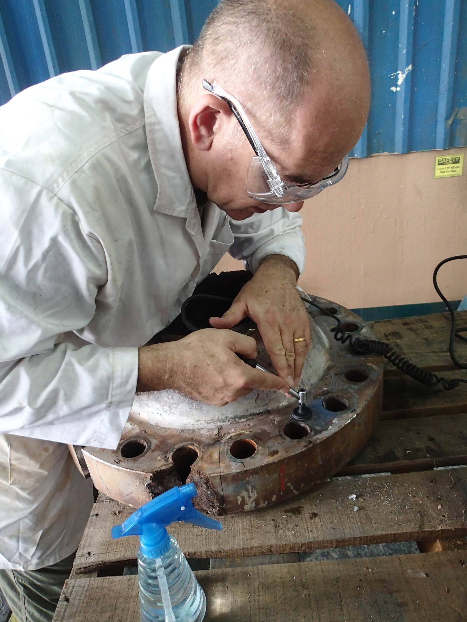 An engineer examining a failed component under laboratory conditions as part of an independent technical assessment